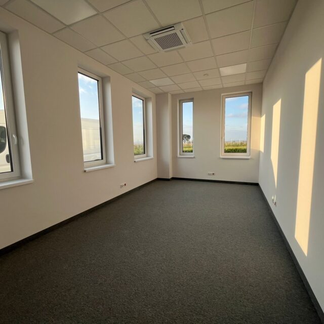 Wnętrze nowego pomieszczenia biurowego z dużymi oknami w realizacji 7R Barniewice dla Blackonwhite.