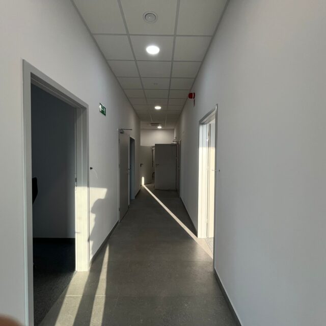 Długi korytarz biurowy z oświetleniem LED wykonany w ramach realizacji 7R Barniewice.