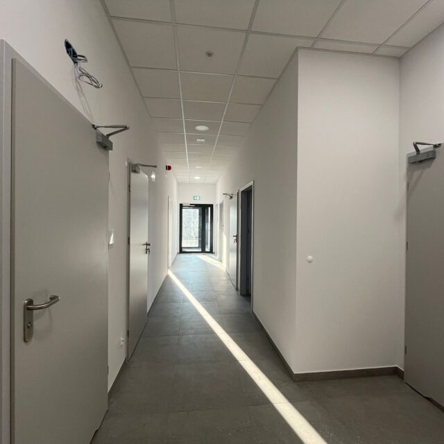 Nowoczesny korytarz biurowy z wieloma wejściami, wykonany w ramach projektu 7R Barniewice.