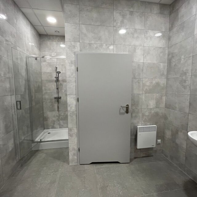 Nowoczesna łazienka z prysznicem i jasnymi płytkami zrealizowana dla Blackonwhite.