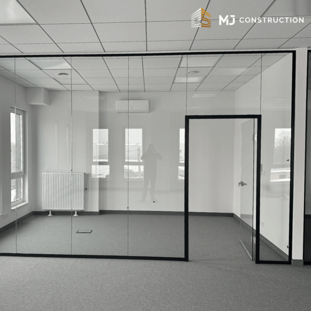 Pomieszczenie biurowe CEFEA z przeszkloną ścianą, oknami i wykładziną